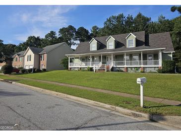 Charming two-story home with a welcoming porch and well-manicured lawn, nestled in a suburban neighborhood at 4680 Duval Point Sw Way, Snellville, GA 30039
