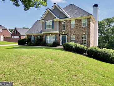 Charming two-story brick home with manicured lawn and inviting curb appeal at 106 Big Cotton Trl, Mcdonough, GA 30252