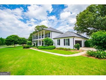 Sprawling two-story home with a manicured lawn and side-entry garage at 1074 Glenloch Rd, Roopville, GA 30170