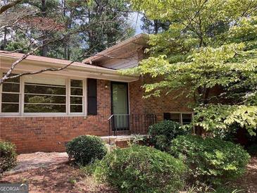 Charming brick home with large windows, black shutters and well-maintained landscaping at 3746 Gladney Dr, Atlanta, GA 30341