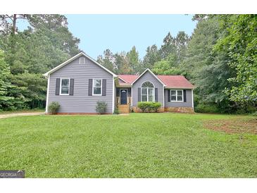 Charming one-story home featuring gray siding, black shutters, and a well-maintained front yard at 85 Holly Springs Rd, Sharpsburg, GA 30277