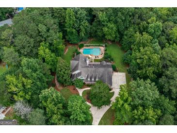 Stunning aerial view of a private estate with pool, lush landscaping, and circular driveway nestled among mature trees at 140 Silvermere, Fayetteville, GA 30215