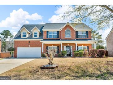 Charming two-story brick home with manicured lawn and attached two-car garage at 362 Interlake Pass, Mcdonough, GA 30252