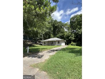 Charming single-story home nestled among lush trees with a long driveway at 1597 Joseph E Boone Nw Blvd, Atlanta, GA 30314