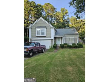 Charming home featuring a well-manicured lawn, attached garage, and inviting curb appeal at 620 Ashton Ln, Lawrenceville, GA 30044