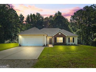 Charming home featuring a well-manicured lawn, complemented by a two car garage and brick facade at 315 Antioch Road, Mcdonough, GA 30252