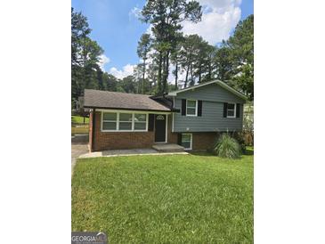 Charming house with a mix of brick and gray siding, complimented by a well-manicured lawn at 993 Roosevelt Se Dr, Atlanta, GA 30354