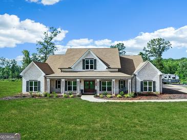 Charming, light brick home featuring a welcoming front porch and lush, green lawn at 357 Old Driver Rd, Whitesburg, GA 30185