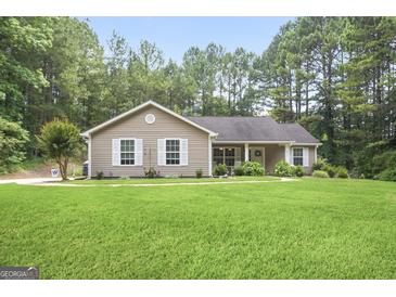Charming single-story home with a well-manicured lawn and surrounded by lush greenery and mature trees at 8340 Highway 54, Sharpsburg, GA 30277