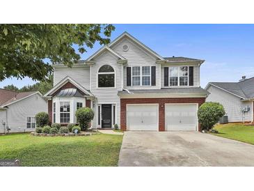 Two-story home with manicured lawn, brick accents, two-car garage, and black shutters at 1255 Silverstone Trl, Jonesboro, GA 30238