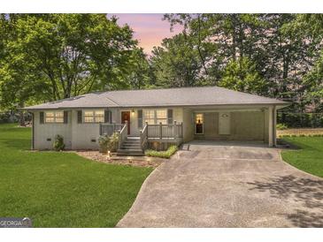 Charming brick home with a well-maintained lawn and a covered carport offers a welcoming curb appeal at 2164 Old Rex Morrow Rd, Morrow, GA 30260