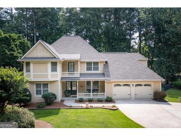 Charming two-story home featuring a spacious front porch, three-car garage, and beautifully landscaped front yard at 148 Lakeside Dr, Peachtree City, GA 30269