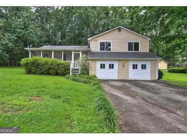 Charming two-story home features a screened porch, two-car garage, and a mature landscaped yard at 3681 Chestnut Lake Ct, Jonesboro, GA 30236