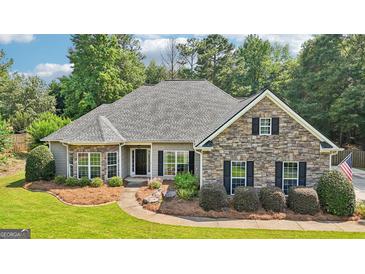 Charming single-story home features a stone facade, manicured landscaping, and a welcoming front porch at 320 Silverbell Ln, Sharpsburg, GA 30277