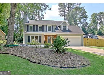 Charming two-story home featuring a well-manicured lawn, inviting curb appeal, and an attached two-car garage at 345 Summer Pl, Peachtree City, GA 30269