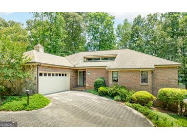 Charming brick home with a two-car garage and lush landscaping along a paved driveway at 1919 Lake Lucerne Sw Way, Lilburn, GA 30047