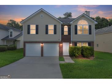 Charming two-story home with a well-maintained lawn, two-car garage, and brick and vinyl siding at 2655 Virginia Cv, Riverdale, GA 30296