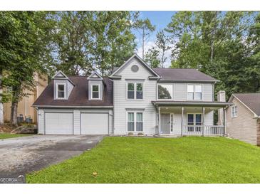 Charming two-story home with a covered front porch, attached two-car garage and a lush green lawn at 539 Riverbirch Trce, Stone Mountain, GA 30087