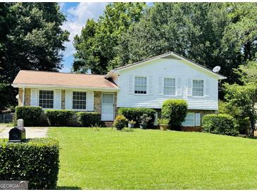 Charming home with a lush front yard, well-maintained landscaping, and classic white shutters at 8436 Magnolia Dr, Jonesboro, GA 30238