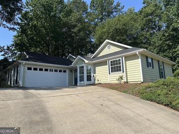 Charming single-story home with a two-car garage, complemented by mature trees and a well-maintained front yard at 539 Horseshoe Cir, Stockbridge, GA 30281
