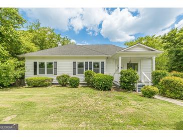 Charming one-story home with white siding, black shutters, and lush green landscaping at 1493 Vesta Ave, Atlanta, GA 30337