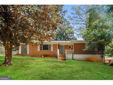 Charming brick home featuring a cozy front porch and lush green lawn at 2138 Rachael Se St, Atlanta, GA 30315