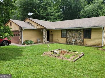 Ranch-style home with yellow siding, stone accents, and a well-maintained lawn at 259 Independence Dr, Jonesboro, GA 30238
