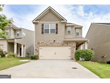 Charming two-story home featuring stone accents, a two-car garage, and manicured landscaping at 529 Dasheill Ln, Atlanta, GA 30349