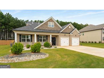 Beautiful brick home features a manicured lawn and attached two car garage at 845 Graeme Dr, Mcdonough, GA 30252
