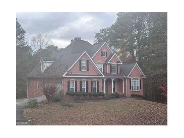 Charming two-story home with a well-maintained lawn and a welcoming front porch at 145 Mill Run, Fayetteville, GA 30214
