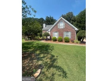Charming single-story home with lush green lawn, mature trees, and well-maintained landscaping at 733 Stonehaven Chase, Mcdonough, GA 30253