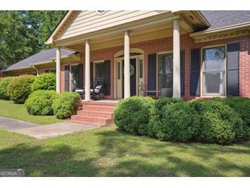 Charming brick home featuring a cozy front porch with classic columns and well-manicured landscaping at 109 Old Virginia Cir, Jonesboro, GA 30236
