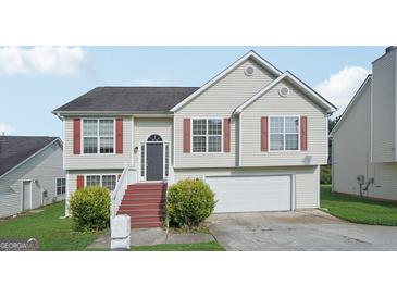 Charming two-story home featuring light siding, red shutters, an attached garage, and well-maintained landscaping at 4738 Golod Way, Lithonia, GA 30038