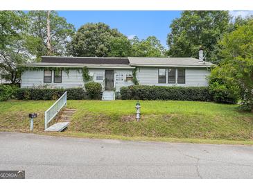 Inviting single-story home featuring a well-maintained lawn and charming curb appeal at 4705 Ernest Dr, Forest Park, GA 30297