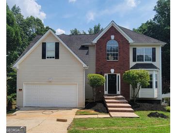 Charming two-story home boasts a manicured lawn, brick accents, and an attached two-car garage at 2587 Mead Ct, Jonesboro, GA 30236