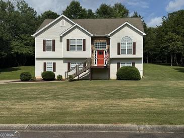 Inviting two-story home with a well-manicured lawn, red front door, and decorative stone accents at 51 Estates Dr, Villa Rica, GA 30180