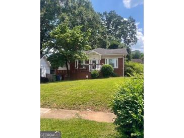 Charming brick home with front porch and a well-maintained lawn and mature trees at 978 Byron Sw Dr, Atlanta, GA 30310
