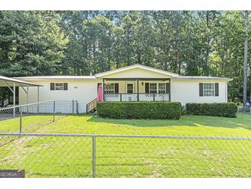 Charming single-story home featuring a quaint porch, green lawn, and fenced yard at 340 Loblolly Rdg, Locust Grove, GA 30248