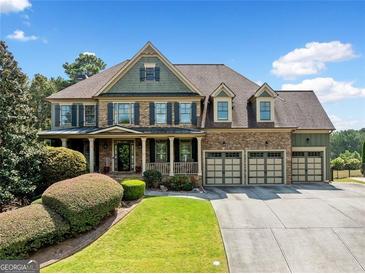 Beautiful, two-story brick home with an inviting porch and three-car garage offers fantastic curb appeal at 5585 Lavender Farms, Powder Springs, GA 30127