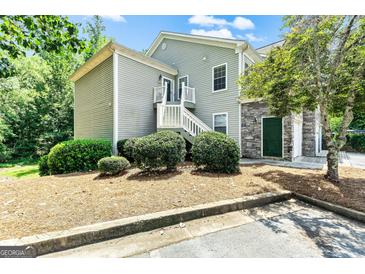 Two-story home with light gray siding, stone accents, stairs, and lush landscaping at 512 Las Brasis Ct, Peachtree City, GA 30269