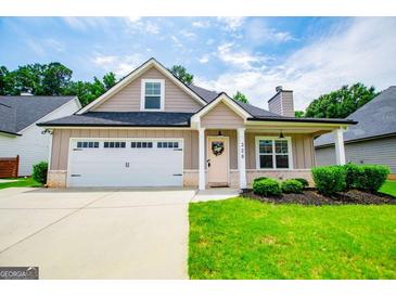 Charming single Gathering home featuring an attached two-car garage and manicured front lawn at 328 Brookstone Dr, Carrollton, GA 30116