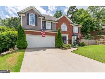 Charming two-story home featuring a brick facade, gray siding, an attached garage, and a well-manicured front lawn at 130 Bexar Ct, Johns Creek, GA 30022