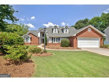 Beautiful single-Gathering home with a well-manicured lawn, brick accents and a two-car garage at 316 Kensington Dr, Peachtree City, GA 30269