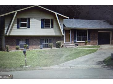 Charming home featuring a well-manicured lawn and a classic brick facade at 8778 Homewood Ct, Riverdale, GA 30274