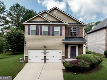 Charming two-story home with a two-car garage, well-maintained lawn, and purple shutters at 9132 Overlook Dr, Jonesboro, GA 30238