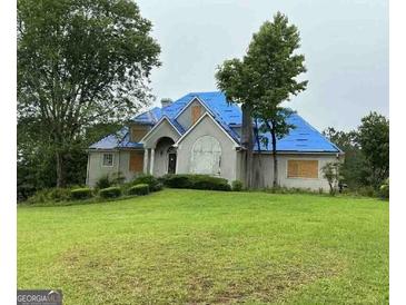Sprawling two-story home with a covered roof on a large front yard at 145 Windy Ridge Ct, Fayetteville, GA 30214