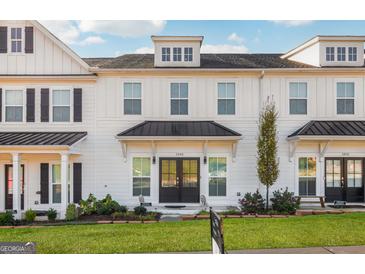 Charming townhome with white siding, black roof, and a well-manicured lawn and landscaped garden at 1848 Eastmore Ave, Conyers, GA 30094