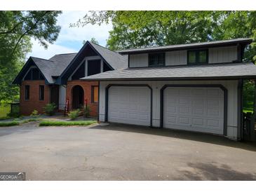 Charming two-story home featuring a two-car garage, brick accents and mature trees at 45 Surrey Chase Dr, Social Circle, GA 30025