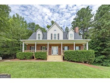 Charming two-story brick home with a welcoming front porch and well-manicured landscaping at 949 Amelia Rd, Locust Grove, GA 30248