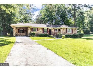 Charming brick home with a well-manicured lawn and covered parking at 650 Lynhurst Sw Dr, Atlanta, GA 30311